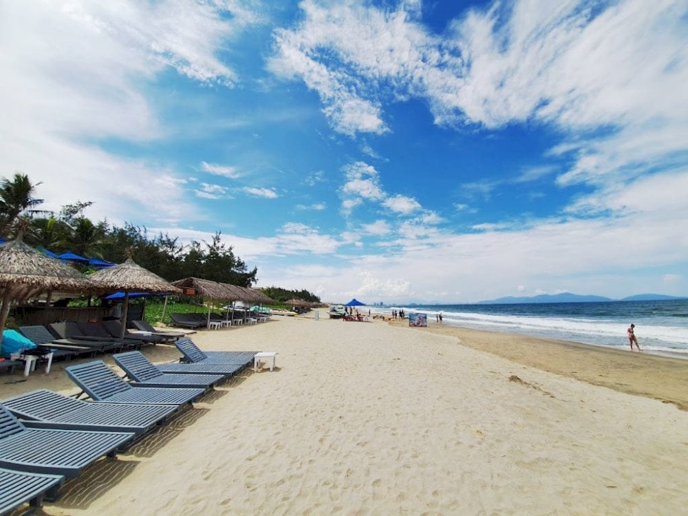 Relax at An Bang Beach with warm waters and moderate temperatures, perfect for swimming, sunbathing, and water sport